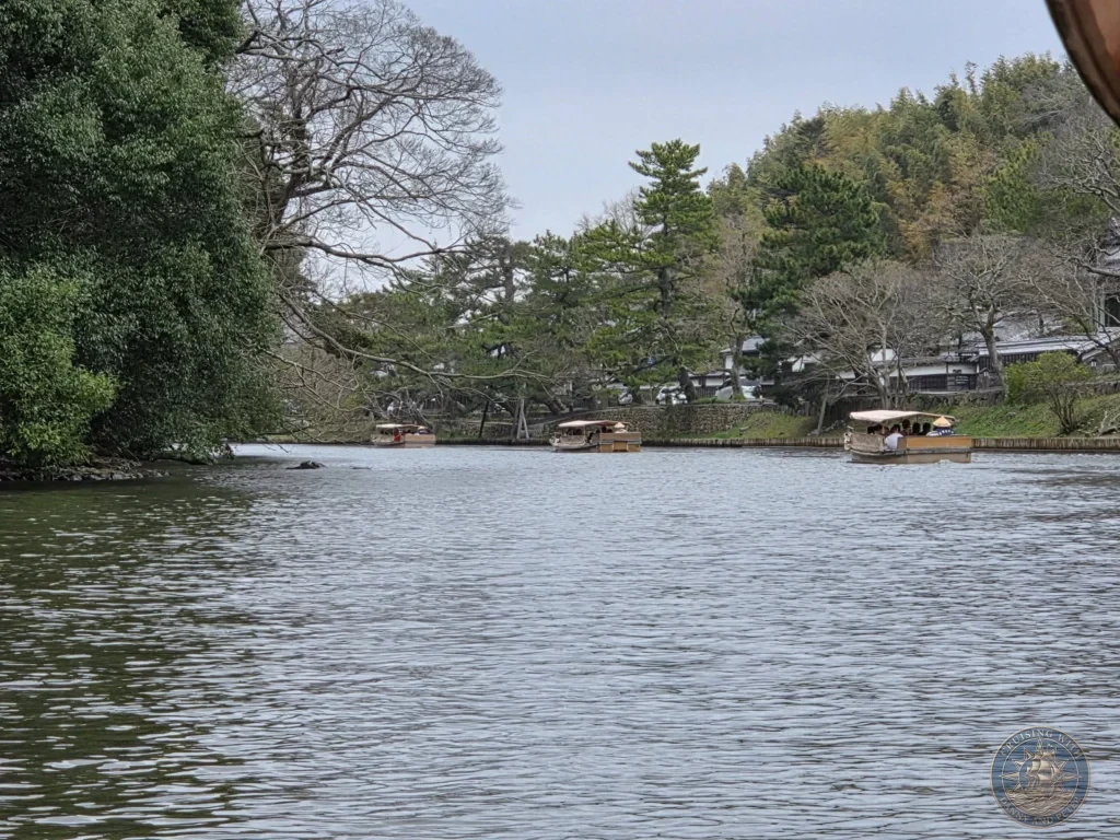 Multiple covered Horikawa sightseeing boats cruising along the open waters of the castle moat lined with pine trees and traditional buildings in Matsue during a shore excursion from Sakaiminato Japan Cruise Port Guide, DIY Sakaiminato Cruise Port to City Center, Things to do in Sakaiminato from cruise ship, Westerdam Sakaiminato Docking Location, One day in Sakaiminato Japan itinerary by Danny and Peter.