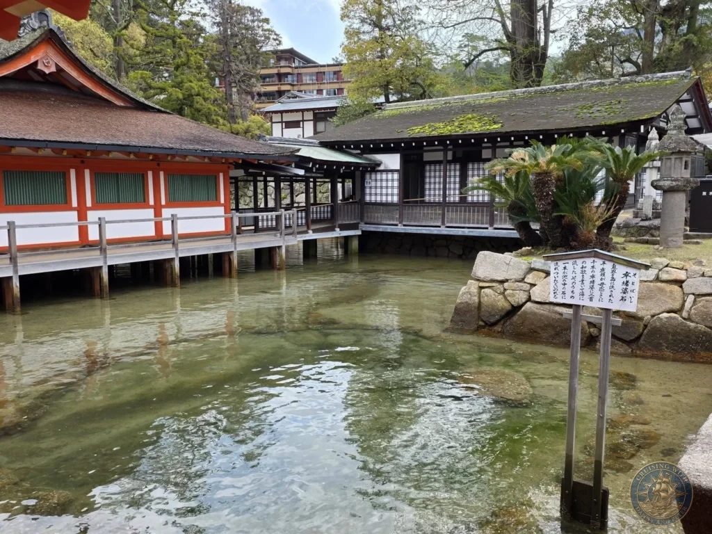Hiroshima Japan Cruise Port Guide 2026 – Insider Tips & One Day Itinerary 37 View of the shallow tidal water flowing beneath the wooden boardwalks and historic buildings near the Sotoba-ishi stone marker at Itsukushima Shrine on Miyajima Island in Hiroshima Japan. Hiroshima Japan Cruise Port Guide, DIY Hiroshima Cruise Port to City Center, Things to do in Hiroshima from cruise ship, Westerdam Hiroshima Docking Location, One day in Hiroshima Japan itinerary by Danny and Peter.