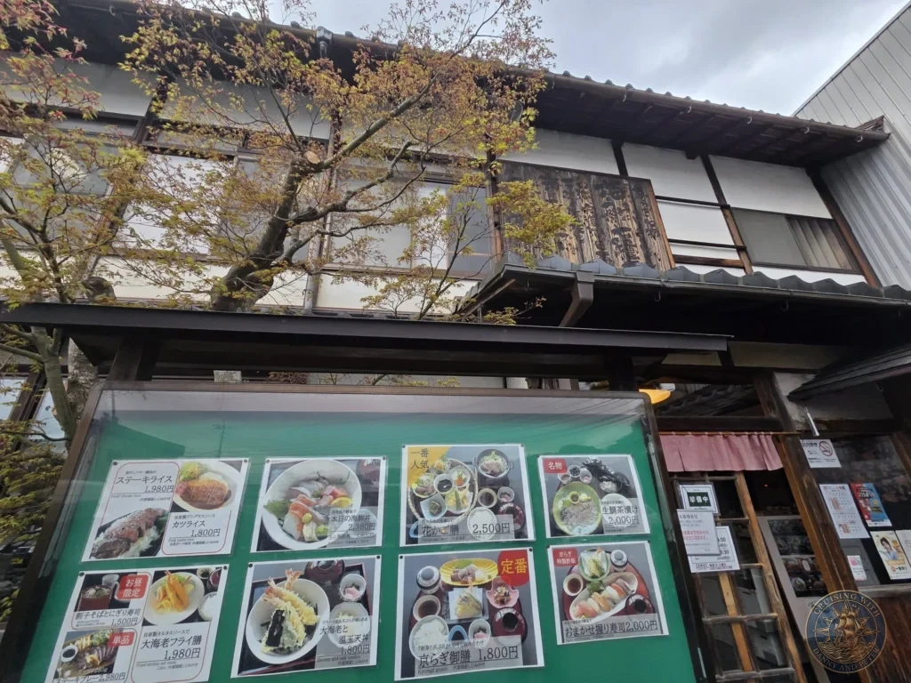 Exterior view of Kyoragi restaurant featuring a traditional dark wood facade and a large green menu board displaying photos and prices of Japanese set meals in Matsue during a shore excursion from Sakaiminato Japan Cruise Port Guide, DIY Sakaiminato Cruise Port to City Center, Things to do in Sakaiminato from cruise ship, Westerdam Sakaiminato Docking Location, One day in Sakaiminato Japan itinerary by Danny and Peter.