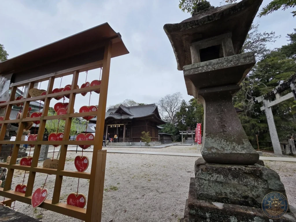 Traditional stone lantern and wooden rack filled with heart-shaped red ema votive plaques on the grounds of Matsue Shrine near Matsue Castle during a shore excursion from Sakaiminato Japan Cruise Port Guide, DIY Sakaiminato Cruise Port to City Center, Things to do in Sakaiminato from cruise ship, Westerdam Sakaiminato Docking Location, One day in Sakaiminato Japan itinerary by Danny and Peter.
