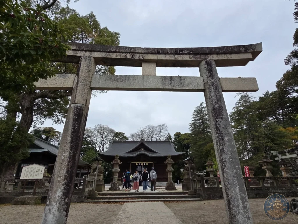 Large weathered stone torii gate framing the main entrance hall of Matsue Shrine surrounded by mature trees during a shore excursion from Sakaiminato Japan Cruise Port Guide, DIY Sakaiminato Cruise Port to City Center, Things to do in Sakaiminato from cruise ship, Westerdam Sakaiminato Docking Location, One day in Sakaiminato Japan itinerary by Danny and Peter.