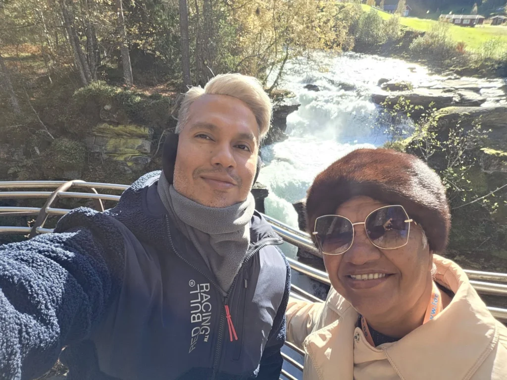 Danny taking a selfie at the Gudbrandsjuvet Gorge viewing platform with rushing river waters in the background during a Holland America Rotterdam excursion. Things to do in Ålesund from cruise ship, by Danny and Peter.