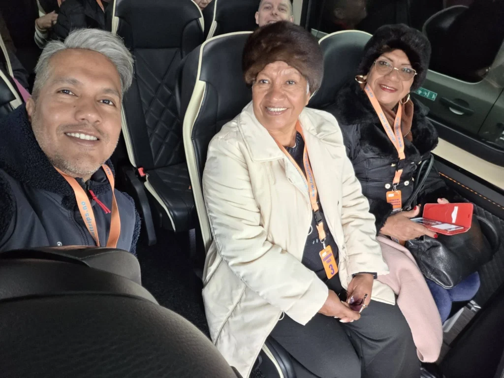Danny taking a selfie inside the tour bus with his mother, his aunt, and Peter peeking from behind, as they embark on a scenic excursion during a Holland America Rotterdam port call. Things to do in Ålesund from cruise ship, by Danny and Peter.