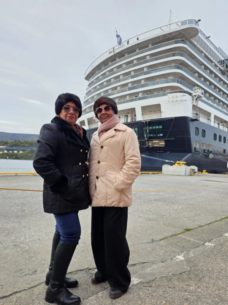 Danny's aunt and mother posing together in warm winter coats on Storneskaia Quay in front of Holland America Line's Rotterdam in Ålesund, Norway. MS Rotterdam Ålesund Docking Location, by Danny and Peter.